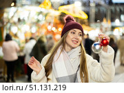 Portrait of dreamily happy girl with Christmas balls in her hands at a street fair in evening. Стоковое фото, фотограф Яков Филимонов / Фотобанк Лори