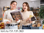 Two girls in store while shopping, choose sweets and chat sweetly. Стоковое фото, фотограф Яков Филимонов / Фотобанк Лори
