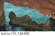 A close-up view of rusted metal with jagged edges, framing a serene body of water. The contrasting textures of rust and the calm blue water create a striking visual interplay. Стоковое видео, видеограф Воловодов Владимир / Фотобанк Лори