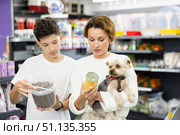Woman with teenage son choosing food for Yorkshire terrier in pet store. Стоковое фото, фотограф Яков Филимонов / Фотобанк Лори