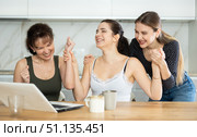 Three happy middle-aged woman expressing joy for winning in the kitchen. Стоковое фото, фотограф Яков Филимонов / Фотобанк Лори