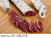 Slicing delicious Spanish smoked sausage fuete. Стоковое фото, фотограф Яков Филимонов / Фотобанк Лори