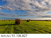 Field with golden haystacks at sunset with a cloudy sky background. Стоковое фото, фотограф Емельянов Евгений Викторович / Фотобанк Лори