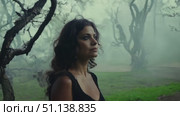 A woman gazes thoughtfully while surrounded by fog and gnarled trees in a mysterious forest. Стоковое AI-видео, аниматор Данила Большаков / Фотобанк Лори