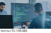 A programmer writes code while facing multiple monitors in a bright office environment. Стоковое AI-видео, аниматор Данила Большаков / Фотобанк Лори