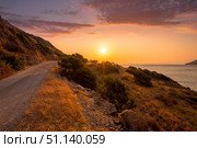 Sunrise on the island of Crete near Spinalonga with sea coast, rocks and dirt road. (2019 год). Стоковое фото, фотограф Емельянов Евгений Викторович / Фотобанк Лори