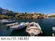 AGIOS NIKOLAUS, GREECE - SEPTEMBER 10, 2019: Lake Vulismeni with boats in the foreground. Редакционное фото, фотограф Емельянов Евгений Викторович / Фотобанк Лори