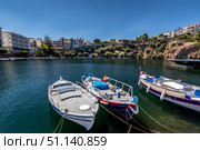 AGIOS NIKOLAUS, GREECE - SEPTEMBER 10, 2019: Lake Vulismeni with boats in the foreground. Редакционное фото, фотограф Емельянов Евгений Викторович / Фотобанк Лори