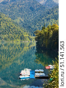 Ritsa, Abkhazia - October 12, 2019: A beautiful clear lake surrounded by high mountains. Beautiful water landscape. Rest on the shore of the reservoir. Стоковое фото, фотограф Наталия Кирсанова / Фотобанк Лори