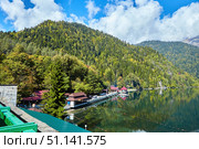 Ritsa, Abkhazia - October 12, 2019: A beautiful clear lake surrounded by high mountains. Beautiful water landscape. Rest on the shore of the reservoir. Стоковое фото, фотограф Наталия Кирсанова / Фотобанк Лори