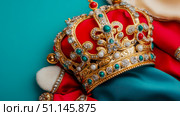 Magnificent Golden Royal Crown Adorned with Sparkling Diamonds, Emeralds, Rubies, and Pearls on Plush Red and Teal Fabric. Стоковое AI-изображение, AI-художник Данила Большаков / Фотобанк Лори