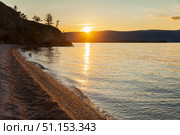 Baikal Lake on summer sunset. View of pebble beach of Olkhon Island on quiet August evening. Picturesque seascape. Natural background. Summer travel. Стоковое фото, фотограф Виктория Катьянова / Фотобанк Лори