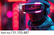 Cyber gamer in VR glasses plays virtual reality game in neon futuristic space. Cyberpunk fashion gaming concept. Young man in metaverse VR virtual game playing concept. Стоковое AI-изображение, AI-художник Ирина Михайличенко / Фотобанк Лори