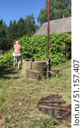Workers are cleaning a mine shaft well. A man pulls out a bucket of dirty water from the well. Vertical video. Стоковое видео, видеограф Vadzim Yakubovich / Фотобанк Лори