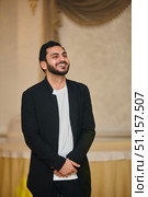A young man with a beard is standing in the room and laughing. Стоковое фото, фотограф Наталия Кирсанова / Фотобанк Лори