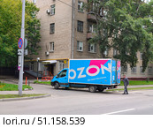 Грузовик закрывает дверцы фургона службы доставки Ozon возле шлагбаума. Доставка в пункт выдачи заказов. Редакционное фото, фотограф Мария Сергеева / Фотобанк Лори