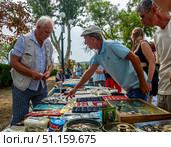 Торговля старыми монетами и значками на стихийном рынке у набережной города Феодосия, Крым. Редакционное фото, фотограф Вячеслав Палес / Фотобанк Лори