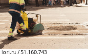 Worker with Asphalt Road Cutting Machine cuts asphalt , banner. Стоковое фото, фотограф Андрей Митин / Фотобанк Лори