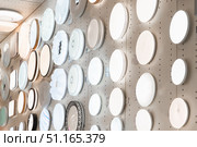 Shop features a diverse collection of modern ceiling lamps and wall sconces, showcasing various designs and styles. Soft light glows from round circular fixtures, perfect for enhancing home interiors. Стоковое фото, фотограф Владимир Разгуляев / Фотобанк Лори