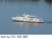 A pleasure boat sails along the River. Pleasure boat cruises along the tranquil waters of the Yenisei River showcasing scenic beauty during a summer day. Стоковое фото, фотограф Владимир Разгуляев / Фотобанк Лори