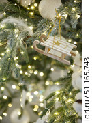 Christmas toy sled hanging on a branch of spruce. Стоковое фото, фотограф Aleksandra Selivanova / Фотобанк Лори