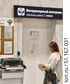 Ветеринарный контроль в аэропорту Шереметьево. Пассажир с  клеткой переноской и документами. Редакционное фото, фотограф Мария Сергеева / Фотобанк Лори