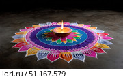 Traditional indian rangoli decorations made with colored powders and a burning diya in the center, celebrating the festival of lights, diwali, a symbol of prosperity and good luck. Стоковое AI-изображение, AI-художник Юрий Поздников / Фотобанк Лори
