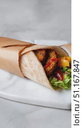 Rotating falafel wrap with fresh greens, peppers, and condiments resting on marble surface, showcasing vibrant culinary composition. Стоковое AI-видео, аниматор Юрий Поздников / Фотобанк Лори