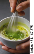 Chef blending matcha powder into white base, whisking green mixture in ceramic bowl with metal utensil, traditional beverage preparation. Стоковое AI-видео, аниматор Юрий Поздников / Фотобанк Лори