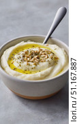Creamy cauliflower puree garnished with toasted pine nuts, fresh herbs, drizzling golden olive oil in ceramic bowl. Стоковое AI-видео, аниматор Юрий Поздников / Фотобанк Лори