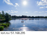Два человека кпаются в водоёме в солнечный летний день. Стоковое фото, фотограф Мария L. / Фотобанк Лори