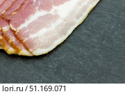 Ломтики качественного бекона на чёрной грифельной доске. Крупный план. Стоковое фото, фотограф Татьяна Васильева / Фотобанк Лори