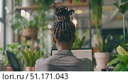 An individual is deeply engaged in work at a desk surrounded by lush greenery. Стоковое AI-видео, аниматор Данила Большаков / Фотобанк Лори