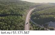 Scenic overview of winding road through lush forest in remote area. Стоковое видео, видеограф Гурьянов Андрей / Фотобанк Лори
