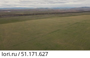 Vast landscape features rolling fields and distant mountains beneath clouds. Стоковое видео, видеограф Гурьянов Андрей / Фотобанк Лори