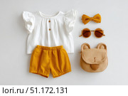 Fashion look of baby girl clothes and accessories. Set of muslin blouse, shorts, hairband and bag. Trendy cute tuff background for newborn. Toddler apparel. Female kid outfit. Pastel child wear set. Стоковое AI-изображение, AI-художник Марина Демидюк / Фотобанк Лори