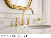 Modern golden faucet and marble stone sink. Stylish white sink, faucets in a light interior. Copper brass tap. Domestic Appliances. Clean bright bathroom. Household equipment. New Contemporary style. Стоковое AI-изображение, AI-художник Марина Демидюк / Фотобанк Лори