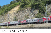 Russia, Sochi, 08/28/2025. A long-distance train moves along the rails along the sea on a sunny day. Стоковое видео, видеограф Васильева Юлия / Фотобанк Лори