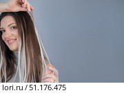 Woman hairstyle after capsule hair extensions showing healthy shiny strands in modern beauty salon. Стоковое фото, фотограф Svetlana Golovco / Фотобанк Лори
