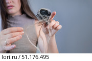 Sad young woman noticing broken strands on hairbrush showing hair thinning and early signs of hair loss. Стоковое фото, фотограф Svetlana Golovco / Фотобанк Лори