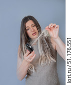 Unhappy woman showing hairbrush with fallen strands hair breakage and early stage hair loss problem. Стоковое фото, фотограф Svetlana Golovco / Фотобанк Лори