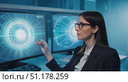 A woman in professional attire engages with high-tech displays in a modern office setting, demonstrating advanced digital interaction. Стоковое AI-видео, аниматор Данила Большаков / Фотобанк Лори