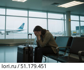 Женщина в отчаянии сидит с чемоданом в аэропорту / A desperate woman sits with a suitcase at the airport. Стоковое AI-изображение, AI-художник Валерий Лукин / Фотобанк Лори