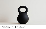 Modern black kettlebell on a minimalist background for fitness routines. Стоковое AI-изображение, AI-художник Katsiaryna Repich / Фотобанк Лори