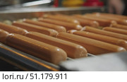 Hot dogs evenly cooked by rollers turning on grill apparatus. Стоковое видео, видеограф Strunov David / Фотобанк Лори