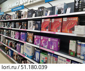 A sales area of ​​a home appliance store. The shelves display various electric kettles, water filters, and components for cleaning systems. In the foreground, boxes with products from the brands Geyser, Aquaphor, Bosch, Polaris, DeLonghi, and others are visible. At the top of the photo, a sign reading "Home Appliances" is visible, as well as a sign reading "Electric Kettles." The products are arranged in an orderly manner, the boxes are bright and varied, which creates the impression of a wide selection of home appliances and kitchen accessories. The atmosphere is typical of an electronics store or a home appliance hypermarket. (2019 год). Редакционное фото, фотограф Анна Кривицкая / Фотобанк Лори