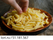 Hand takes golden french fries from plate. Стоковое фото, фотограф Маргарита Кирьякова / Фотобанк Лори