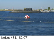 Морской буй в заливе на фоне пришвартованной подводной лодки. Россия, Кронштадт, 4 августа 2025 г. Редакционное фото, фотограф Виталий Шкапский / Фотобанк Лори