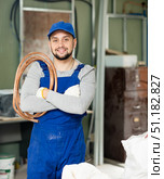 Portrait of satisfied plumber with plastic pipes on his shoulder in house being renovated. Стоковое фото, фотограф Яков Филимонов / Фотобанк Лори