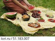 Woman sitting on yellow white blanket and eating watermelon during summer picnic. Стоковое фото, фотограф Маргарита Кирьякова / Фотобанк Лори